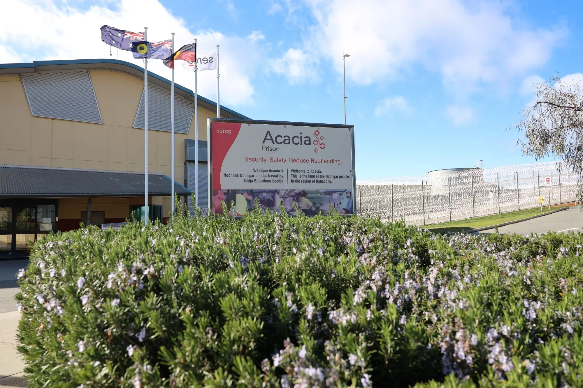 Main prison entrance with a sign and flags in front of a building