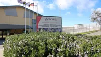 Main prison entrance with a sign and flags in front of a building