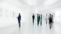 a group of people walking in a white room