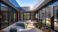 a courtyard with a stone bench and plants