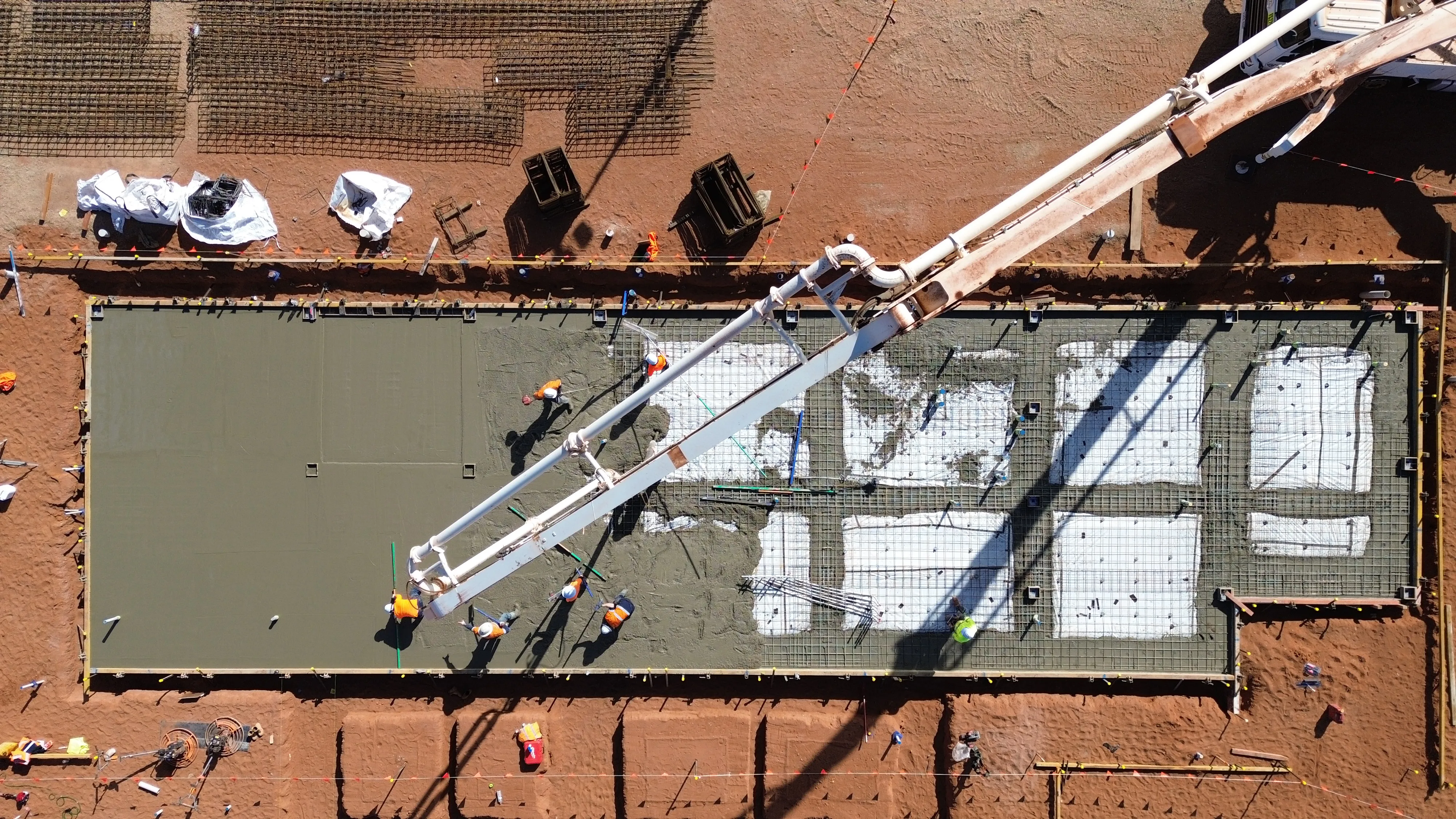 a construction site with workers working on a concrete slab