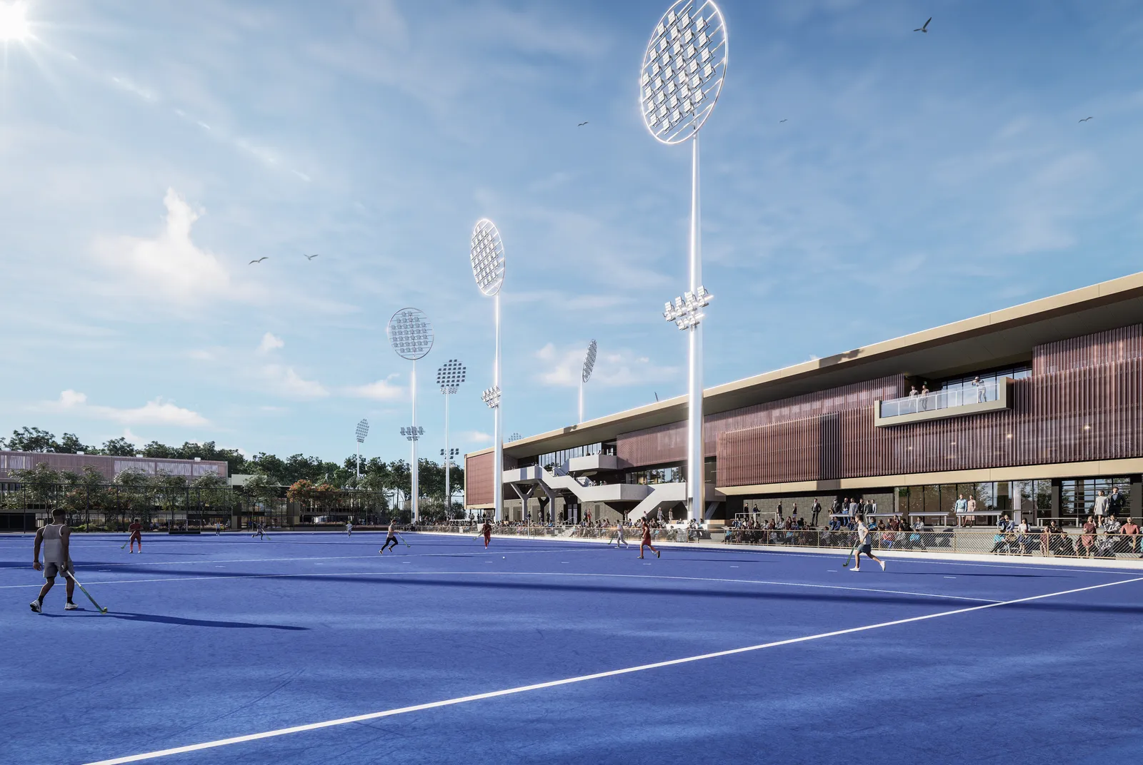 A wide architectural rendering of a modern hockey stadium with a bright blue field, players in action, tall floodlights, spectators along the sideline, and a large grandstand under a clear sky.