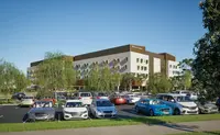 a parking lot with cars and trees in front of a building