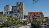 a group of buildings with trees and bushes