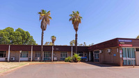 a building with palm trees and blue sky