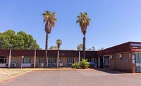a building with palm trees and blue sky
