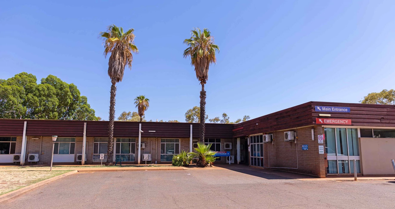 a building with palm trees and blue sky
