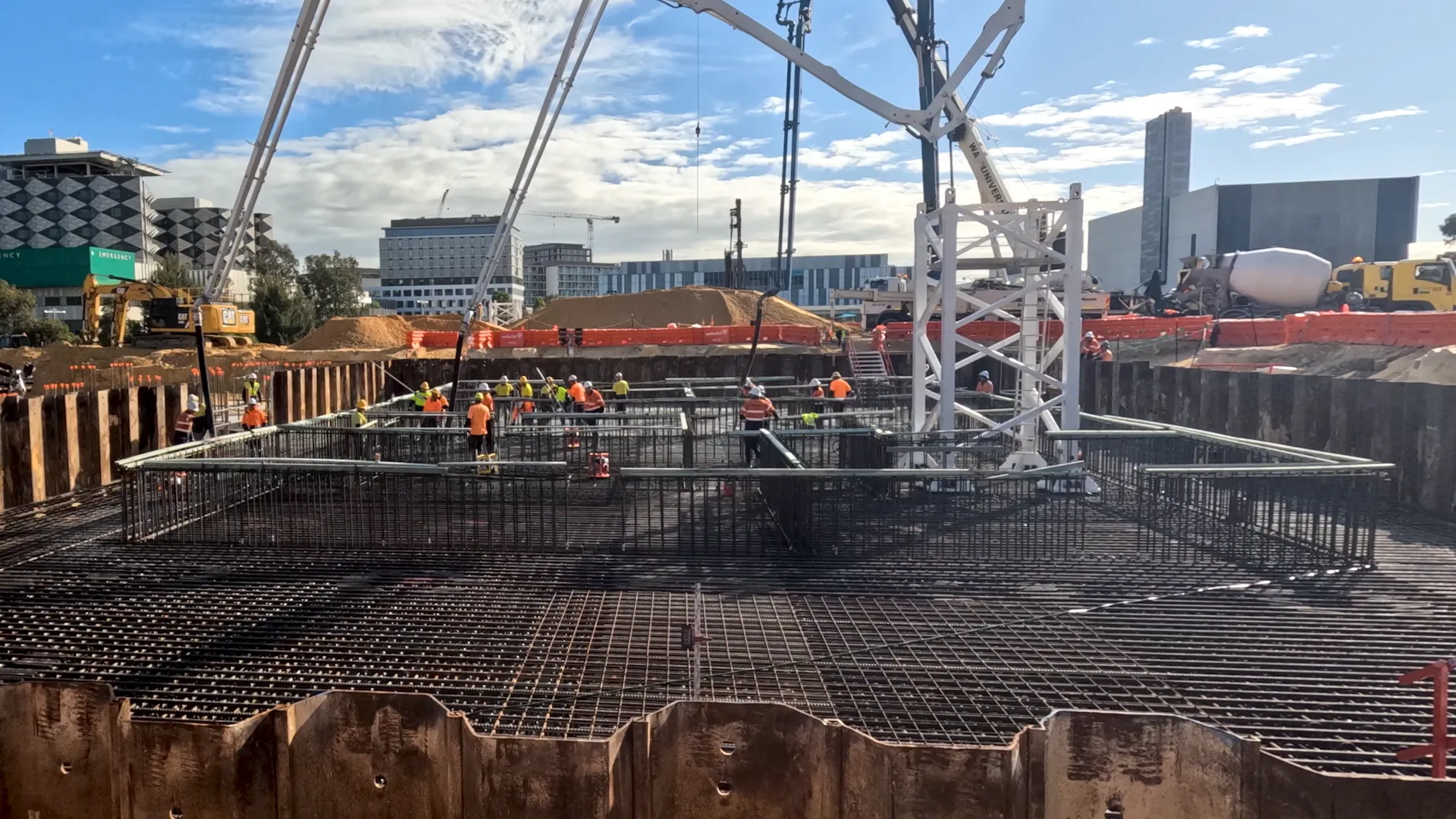 a construction site with cranes and people in orange vests