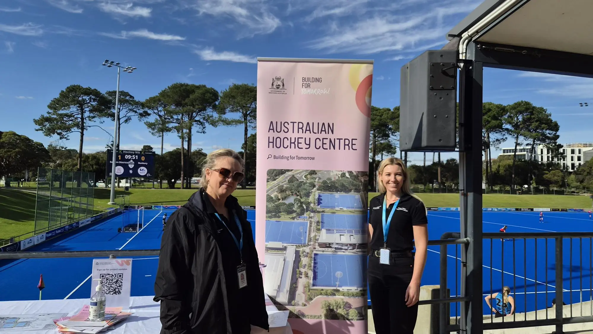 two women standing next to a sign