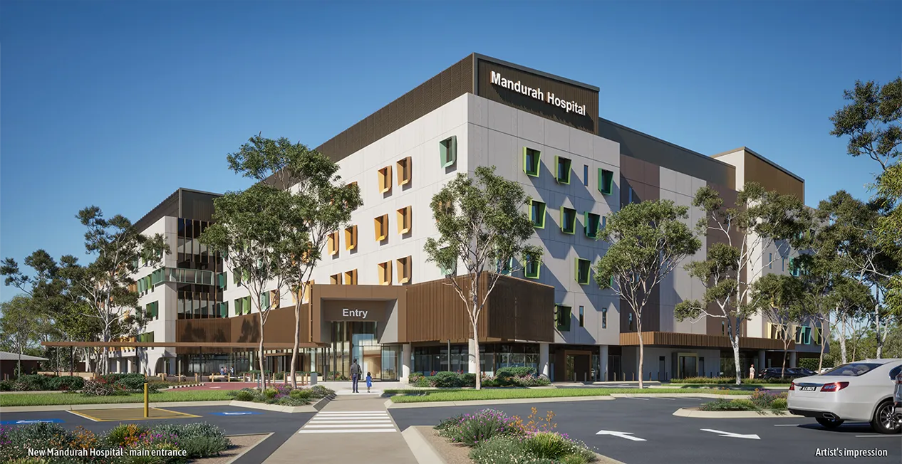 a hospital with trees and a parking lot